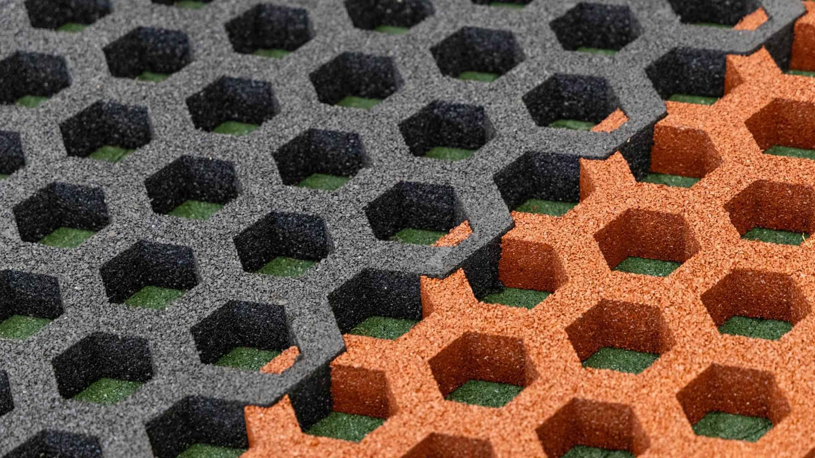 Nahaufnahme von wabenförmigen, wasserdurchlässigen Gummibelägen in Schwarz und Terrakotta.
